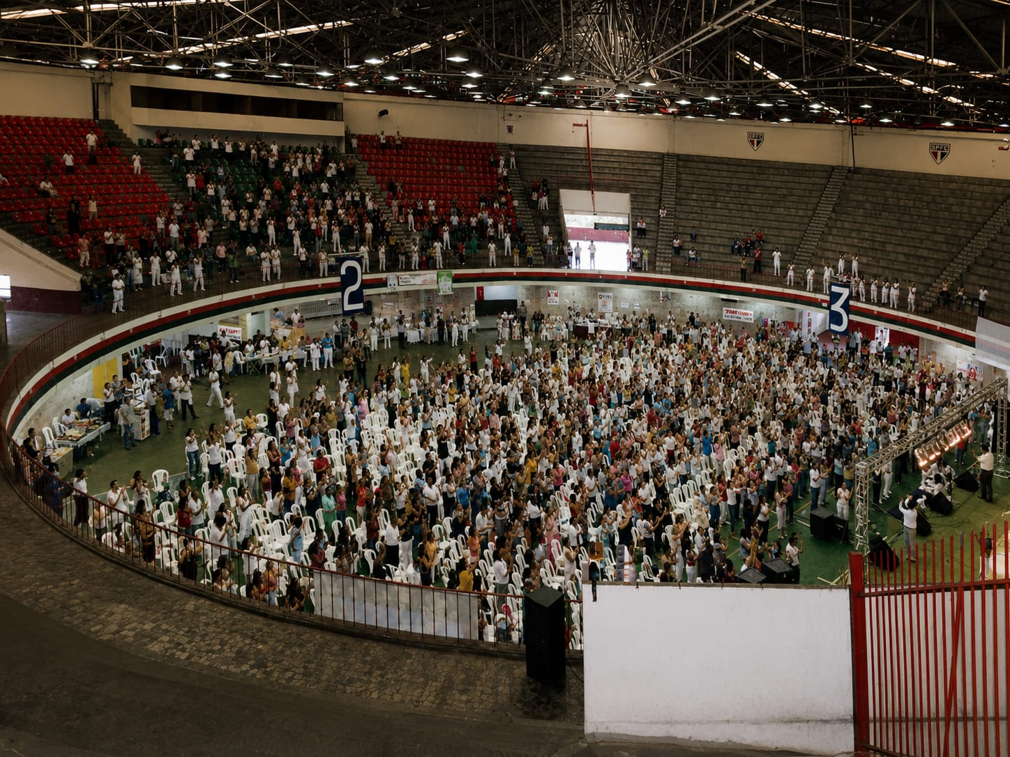 Ginásio com centenas de participantes durante a palestra